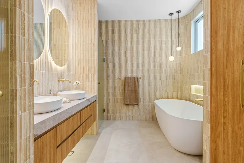 Bagno rifatto con mobile sospeso in legno, lavabi da appoggio e specchi